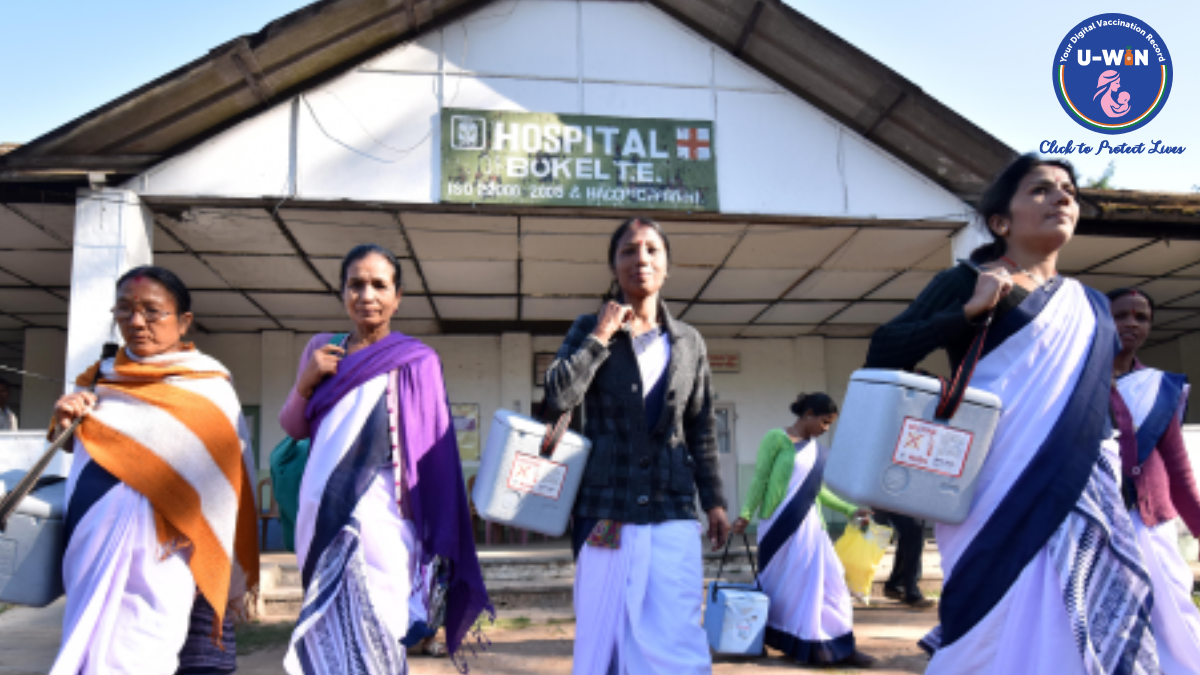 India’s Free HPV Vaccine Launch: A Shield Against Cervical Cancer for 1.2 Crore Girls 1 A group of female healthcare workers in sarees carrying blue medical vaccine carrier boxes outside a rural hospital in India, featuring the U-WIN logo.
