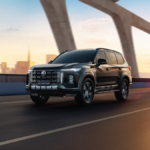 Front view of the MG Majestor SUV on a bridge at sunset, showcasing its bold Mosaic Matrix grille and Dragon Eye DRLs.