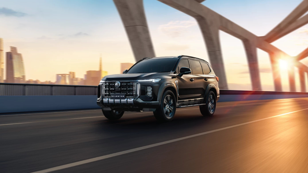 Front view of the MG Majestor SUV on a bridge at sunset, showcasing its bold Mosaic Matrix grille and Dragon Eye DRLs.