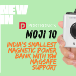 A hand-held Portronics Moji 10 magnetic power bank in White and Mocha, highlighting its ultra-compact camera-inspired design and built-in LED indicator.