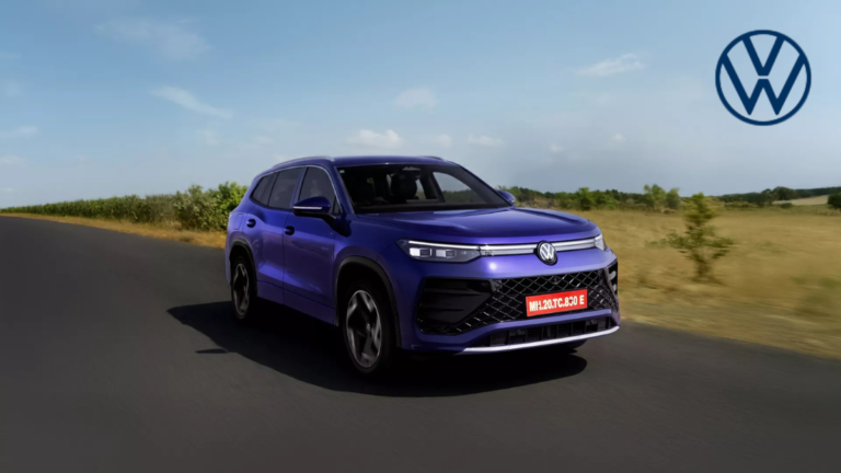 A side-profile action shot of the new Volkswagen Tayron R-Line in Nightshade Blue Metallic driving on an open Indian road, featuring the illuminated VW logo and sporty R-Line bumper.