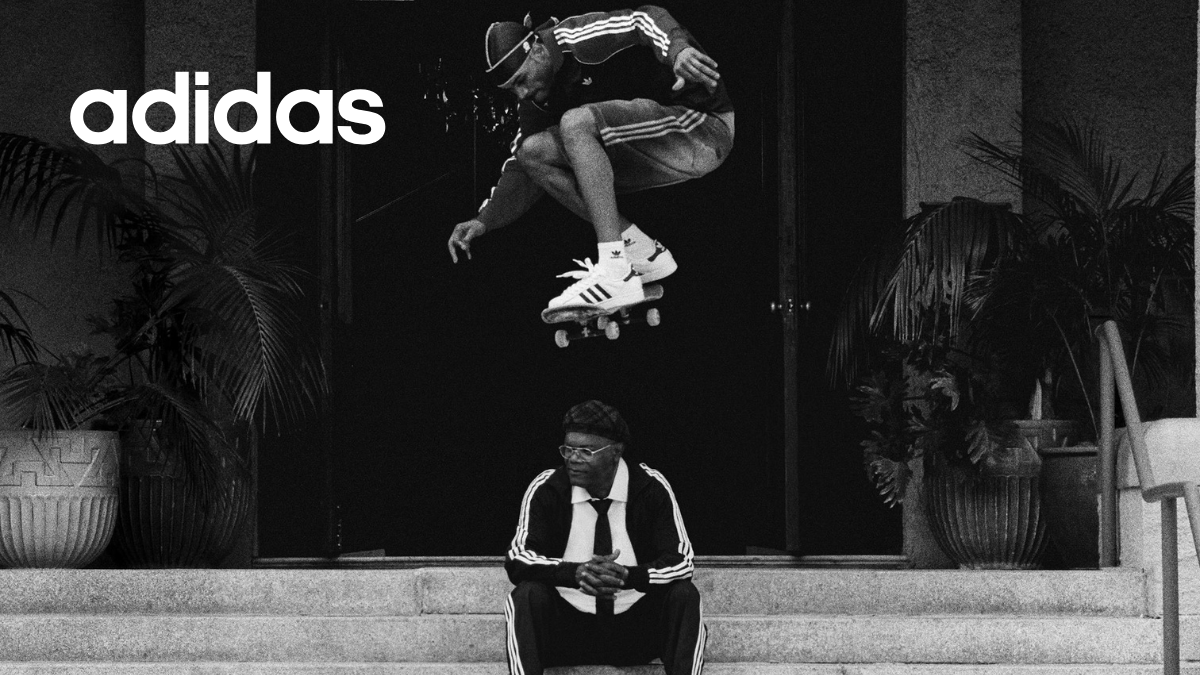 Black and white high-angle shot featuring Samuel L. Jackson seated on stone steps while skateboarding legend Tyshawn Jones performs an aerial trick above him, both wearing adidas Superstars.
