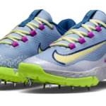 A pair of Nike Domain 3 cricket shoes in Light Fusion Blue and Volt with metal spikes.