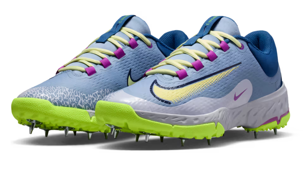 A pair of Nike Domain 3 cricket shoes in Light Fusion Blue and Volt with metal spikes.