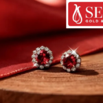 Ruby and diamond stud earrings from Senco Gold's Everlite collection on wood against red fabric.