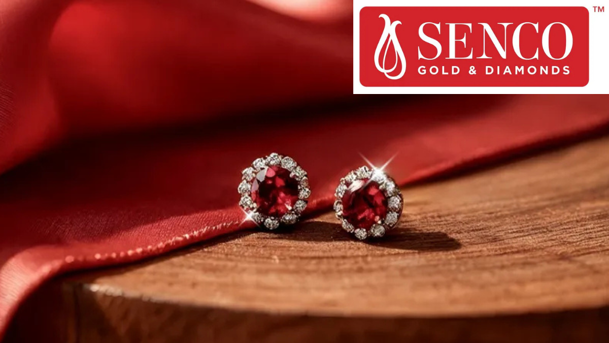Ruby and diamond stud earrings from Senco Gold's Everlite collection on wood against red fabric.