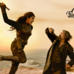 Priyanka Chopra Jonas in a mid-air strike with a weapon against Karl Urban on a rocky Caribbean cliffside in a scene from 'The Bluff'.