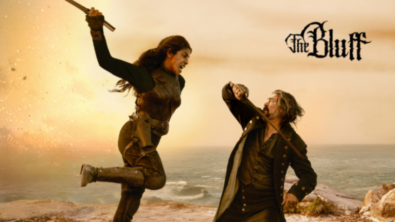 Priyanka Chopra Jonas in a mid-air strike with a weapon against Karl Urban on a rocky Caribbean cliffside in a scene from 'The Bluff'.