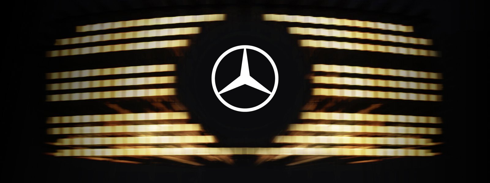 The iconic Mercedes-Benz three-pointed star logo set against a backdrop of illuminated horizontal slats, representing the upcoming 2026 V-Class.