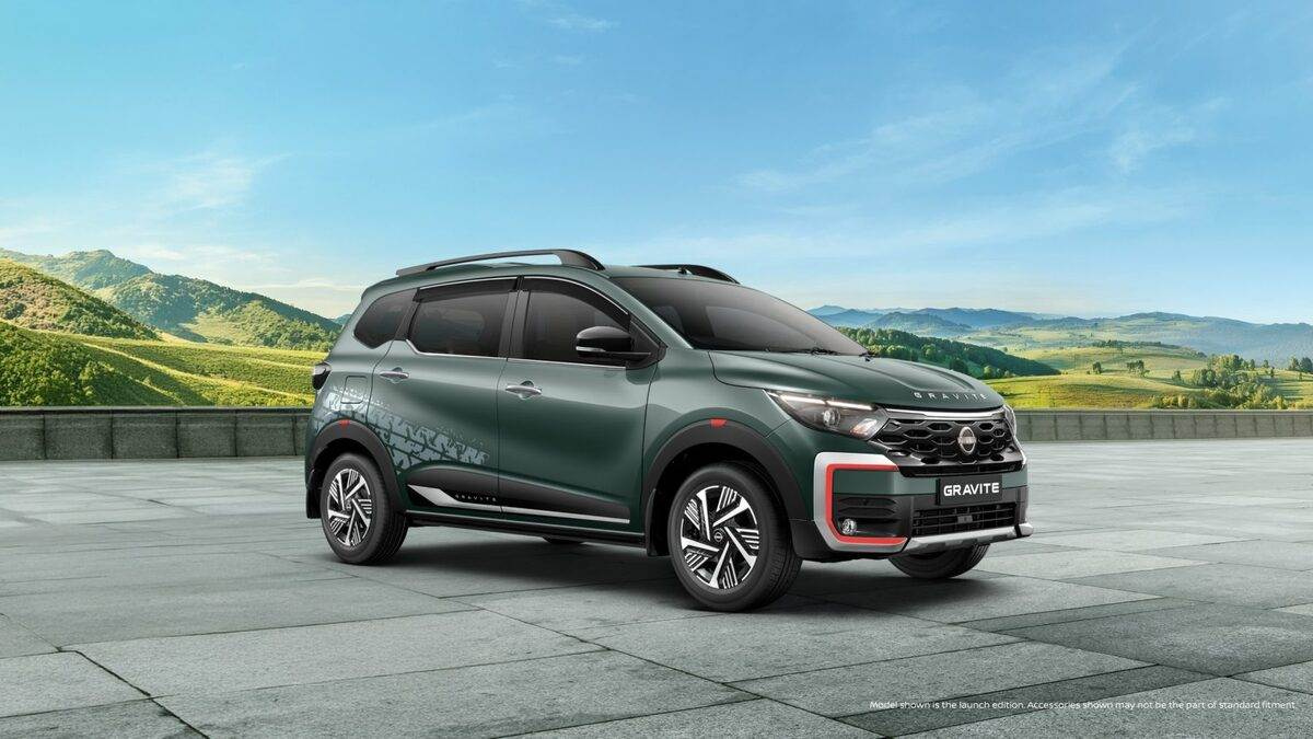 Nissan x Spinny: Upgrade to a New Magnite or Gravite in Just 55 Minutes 1 Side profile of the new Nissan Gravite Launch Edition in Forest Green featuring signature orange bumper accents and tire-track side decals in a scenic landscape.