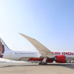 Side profile of an Air India Boeing 787 Dreamliner featuring the new global livery parked on an airport tarmac under a clear blue sky.