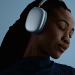 A woman wearing the blue AirPods Max 2 headphones with her eyes closed, demonstrating the immersive Active Noise Cancellation and Personalized Spatial Audio.