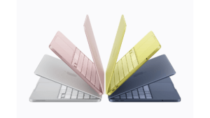 A group of four Apple MacBook Neo laptops in Blush, Indigo, Silver, and Citrus colors arranged in a fan-like display to sh...