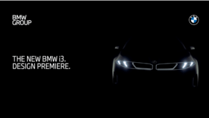 Official teaser image of the new BMW i3 Neue Klasse electric sedan showing illuminated signature LED headlights and wide k...