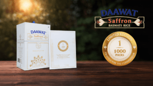 Luxury white and gold packaging of Daawat Saffron Basmati Rice displayed on blue silk fabric with a prominent gold limited...