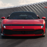Front view of a red modern Ferrari Testarossa concept supercar on a racing track with a concrete barrier background.