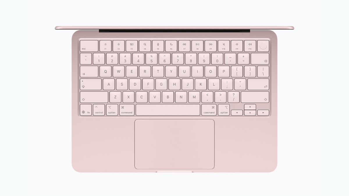 : Top-down view of the MacBook Neo in Blush pink featuring a color-matched Magic Keyboard, large Multi-Touch trackpad, and Touch ID sensor.