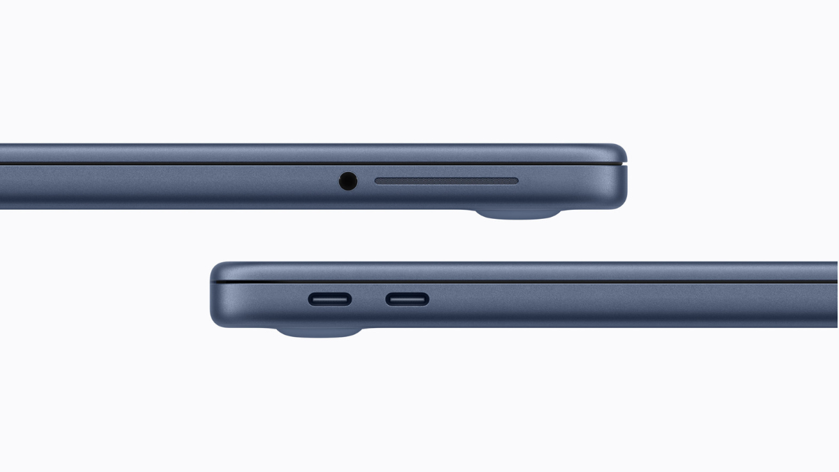 Side profile of the Indigo MacBook Neo showing two USB-C ports on one side and a 3.5mm headphone jack on the other.