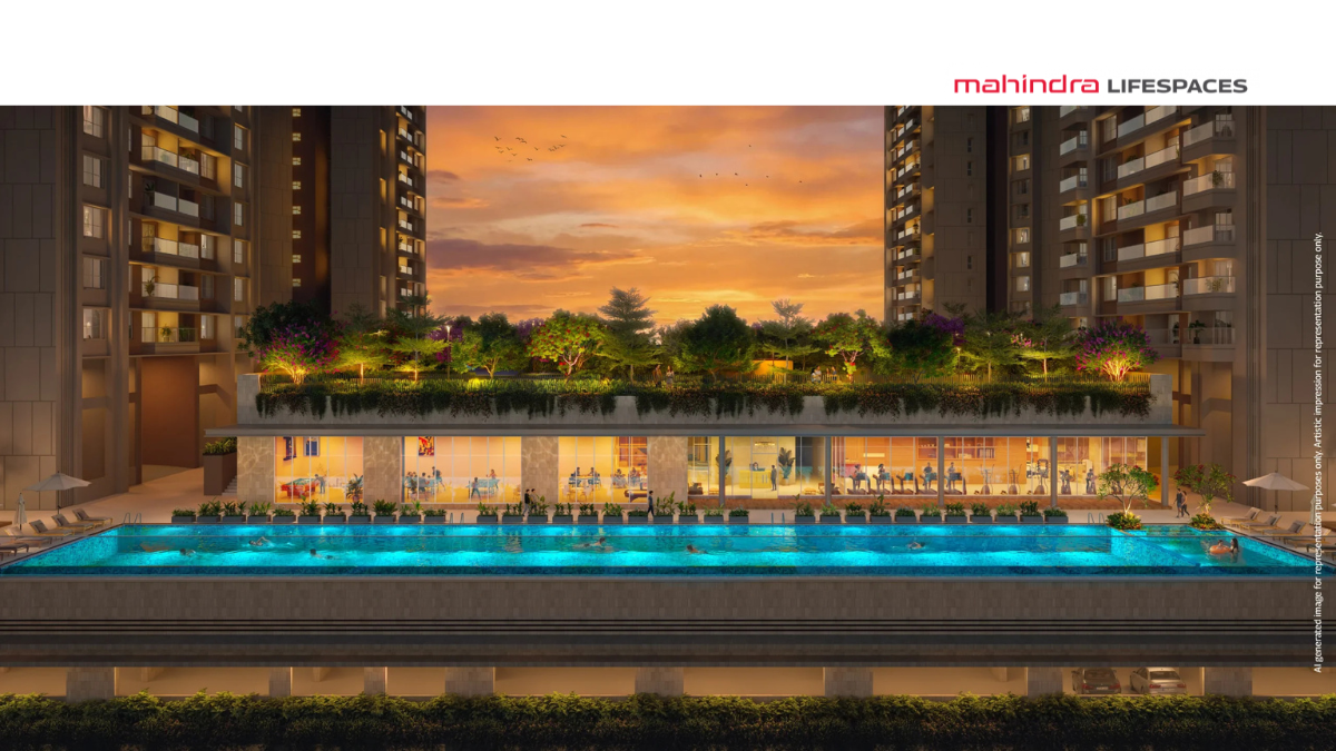 Luxury infinity pool and modern glass-walled clubhouse at Mahindra Rainforest, Kanjur, featuring lush rooftop greenery and residential towers at sunset.
