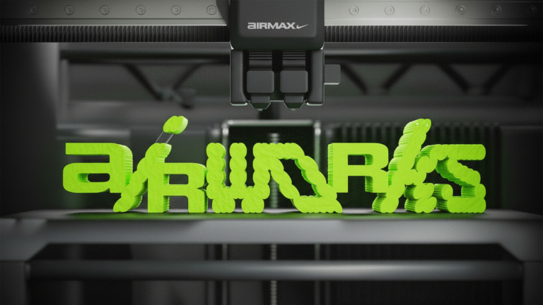A close-up of an industrial 3D printer nozzle manufacturing the neon green "AIR WORKS" logo for the Nike design program.