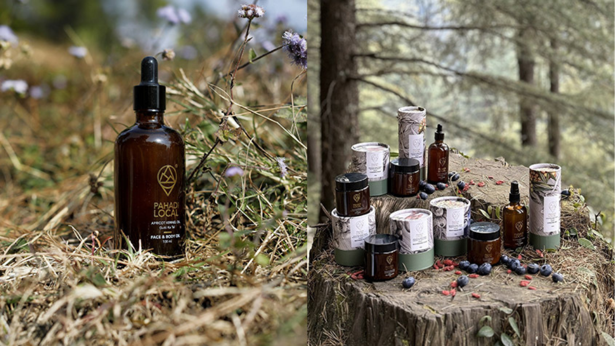 A collection of Pahadi Local natural skincare products, including their signature Gutti Ka Tel (Apricot Kernel Oil) amber dropper bottle and sustainable jars, arranged on a rustic tree stump in a Himalayan forest setting.
