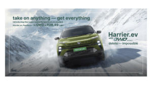 Front view of the Tata Harrier.ev in Seaweed Green driving through snow, featuring the QWD Dual Motor branding and a start...