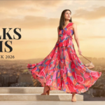 Official campaign graphic for W Walks Paris Fashion Week 2026 featuring a model in a vibrant floral pleated maxi dress with the Eiffel Tower in the background.