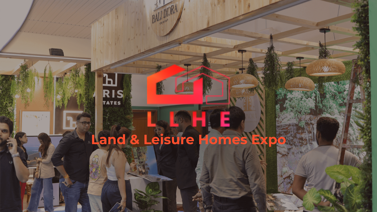 A busy exhibition booth at the Land & Leisure Homes Expo (LLHE) in Mumbai, featuring rustic wooden decor, hanging greenery...