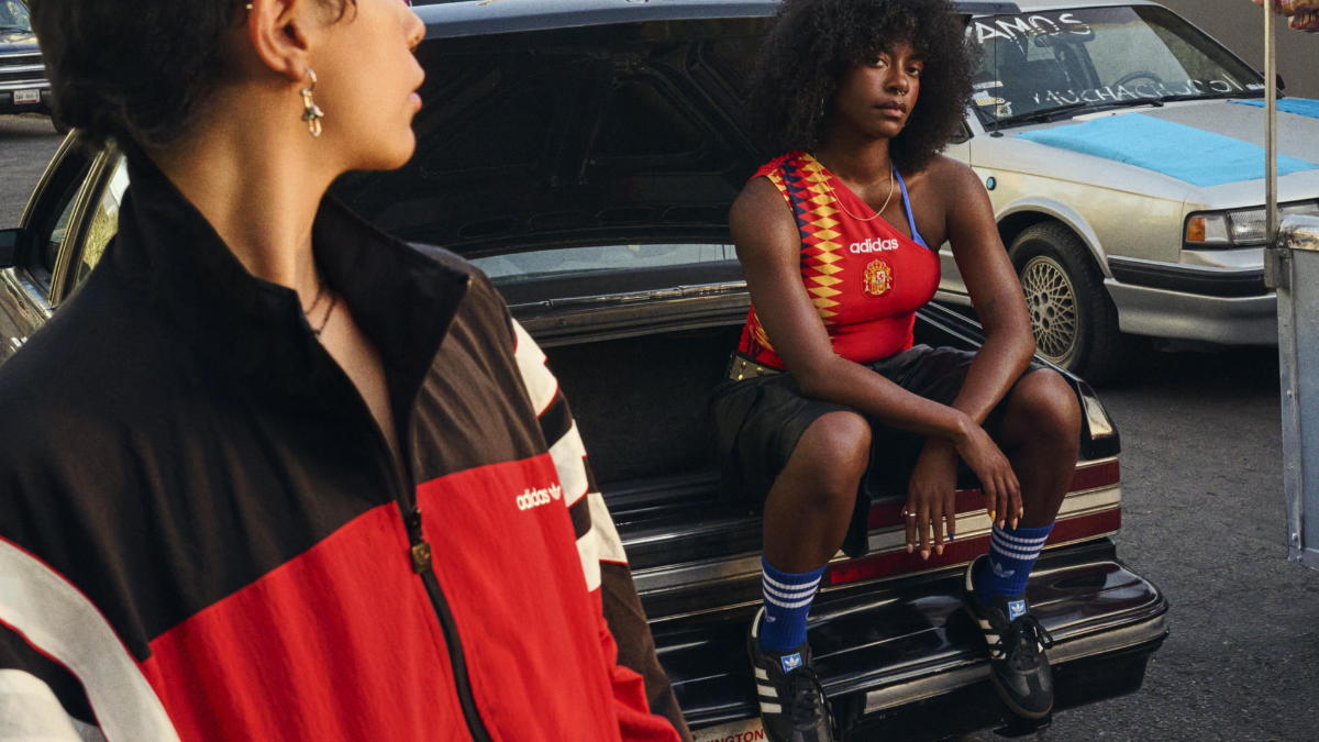 Models near a car trunk wearing adidas Sambas and Handball Spezials with blue socks, paired with a Spain-inspired red bodysuit.