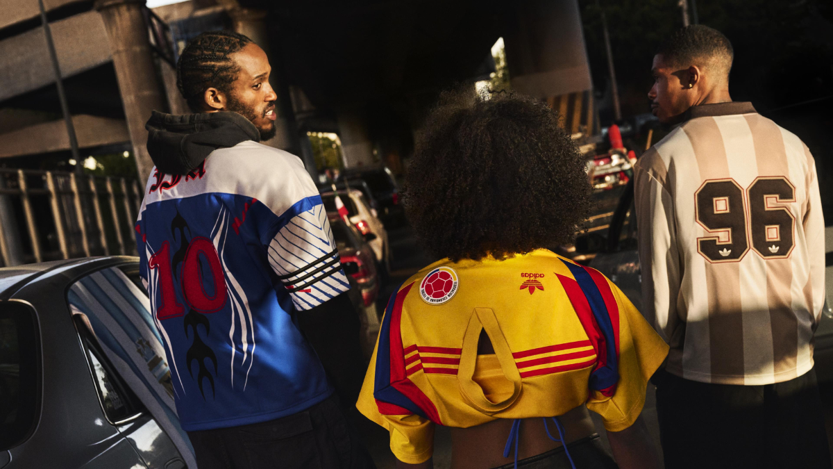 Three fans viewed from behind in a traffic jam wearing vintage-style adidas away jerseys with numbers 10 and 96 and federa...