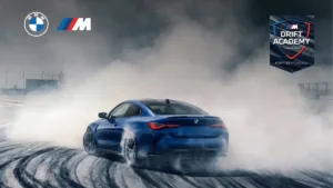 A high-performance blue BMW M4 Competition drifting on a track featuring the official BMW M Drift Academy Class of 2026 br...