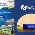 Child in a blue uniform next to Daawat rice bags and processing machinery for the KidZania India factory experience.
