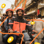 Uber motorcycle taxi with a smiling driver and passenger on a busy Indian street bazaar, with floating Flipkart SuperCoins...