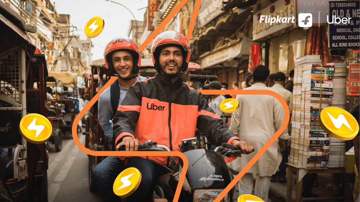Uber motorcycle taxi with a smiling driver and passenger on a busy Indian street bazaar, with floating Flipkart SuperCoins...