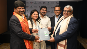 Five individuals exchanging a blue IHG folder in front of an IHG and TGH&R banner during a signing in India.