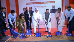 Dignitaries in formal wear using blue shovels to dig soil during a groundbreaking ceremony for a 3D chip plant in Odisha.