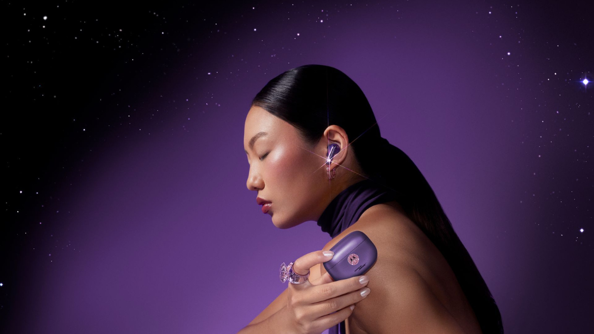 Profile of a woman wearing a violet moto buds 2 plus earbud with crystals and holding the matching case audio