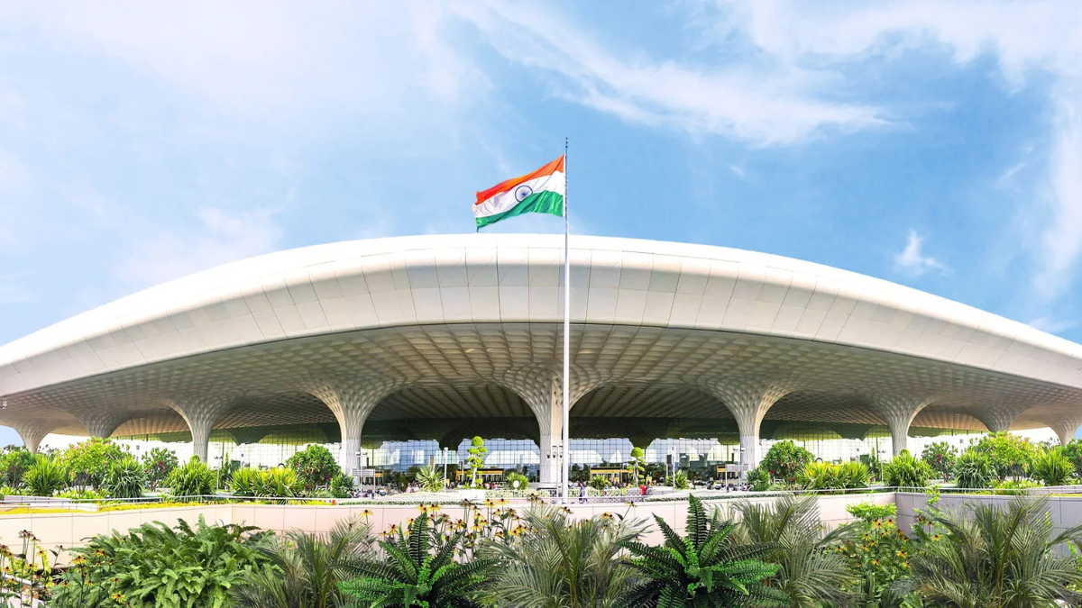 Gate-to-Gate Convenience: Blinkit and Adani Launch India’s First In-Terminal Delivery at Mumbai Airport 1 Daytime exterior view of Chhatrapati Shivaji Maharaj International Airport Terminal 2 in Mumbai with the Indian flag and lush landscaping.