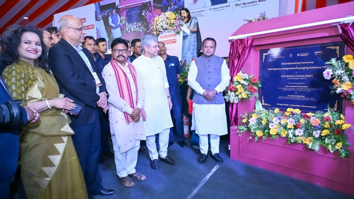 Leaders standing next to a blue ceremonial plaque decorated with flowers at the Info Valley semiconductor site in India.