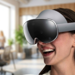 A woman smiling and wearing the Samsung Galaxy XR headset in a modern, sunlit office setting, illustrating the device's ev...