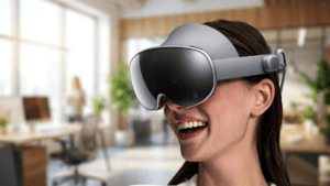A woman smiling and wearing the Samsung Galaxy XR headset in a modern, sunlit office setting, illustrating the device's ev...