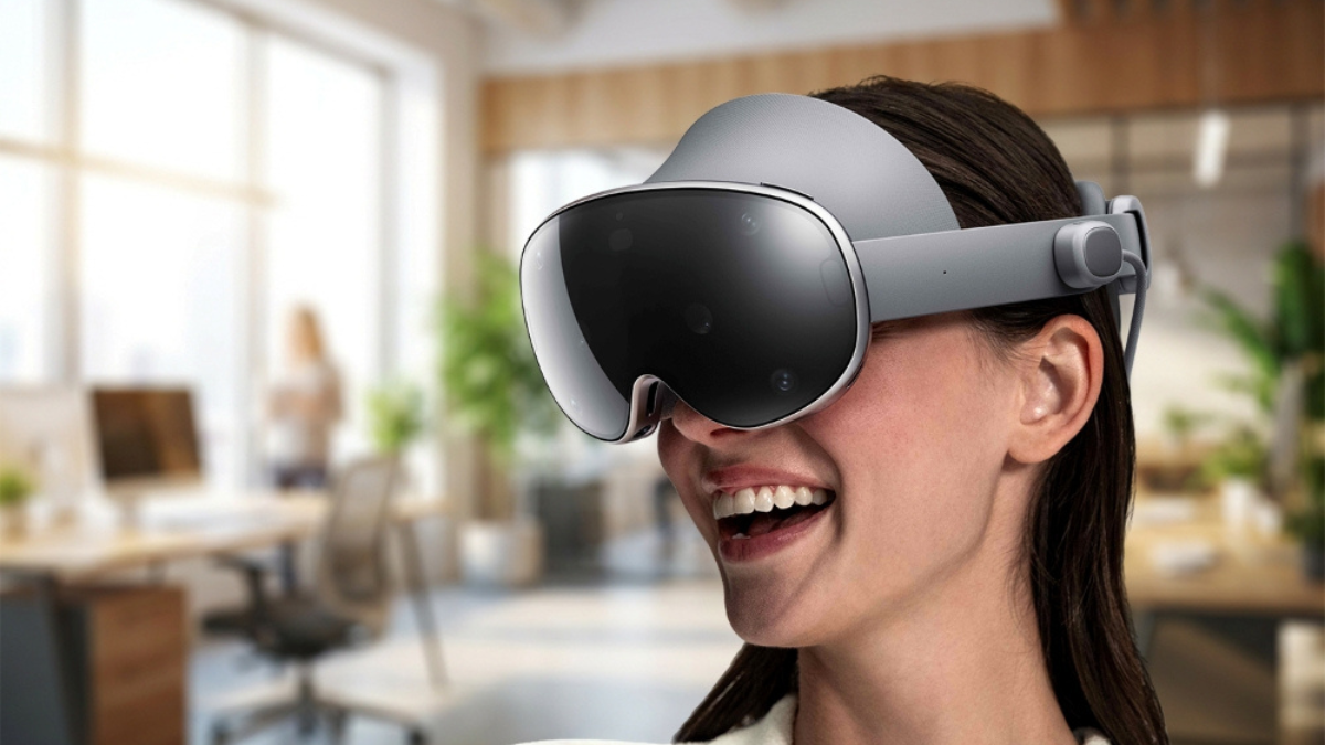 A woman smiling and wearing the Samsung Galaxy XR headset in a modern, sunlit office setting, illustrating the device's ev...