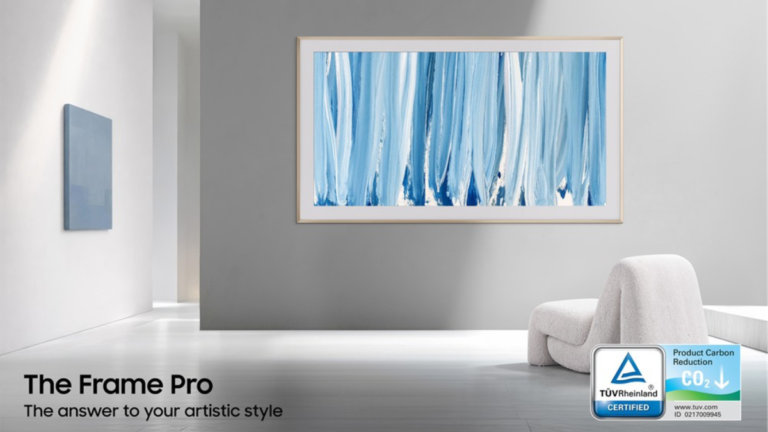 Samsung 2026 TV & Soundbar Lineup Earns Major Eco-Certifications: Premium Tech Meets Sustainability 1 Samsung The Frame Pro TV displaying blue abstract art on a gallery wall with a TÜV Rheinland Product Carbon Reduction CO2 certification badge in the foreground.