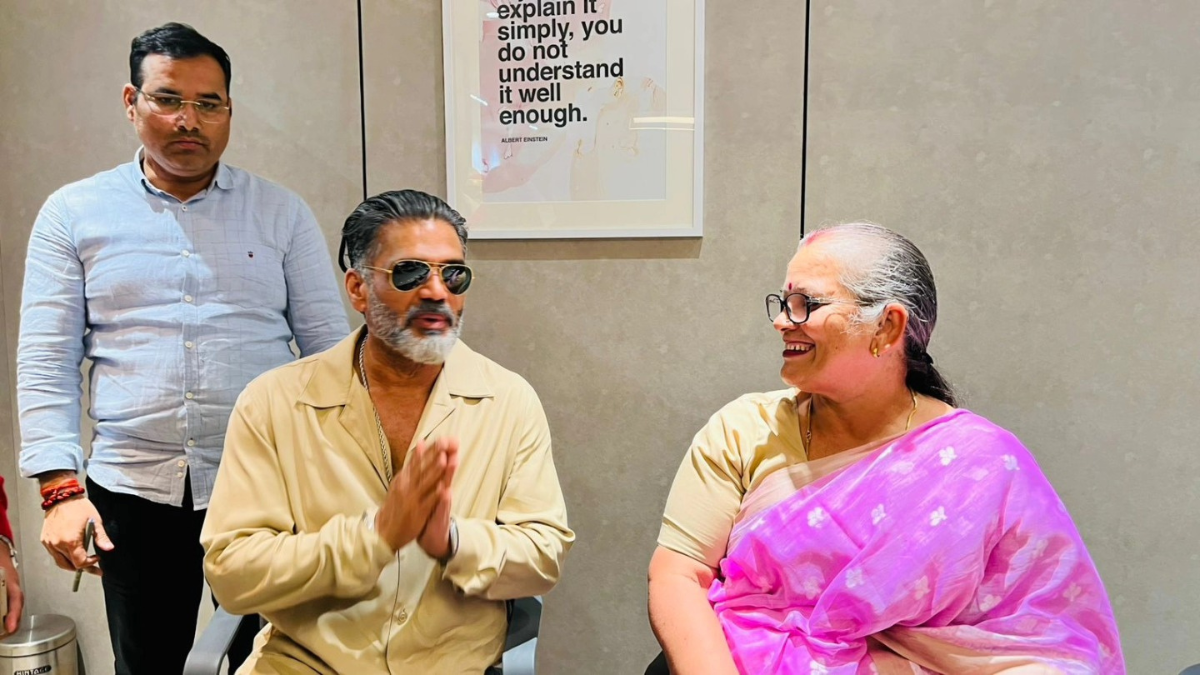 Bollywood icon Suniel Shetty in a tan shirt and sunglasses interacting with Lucknow Mayor Smt. Sushma Kharakwal at the GM Modular event.