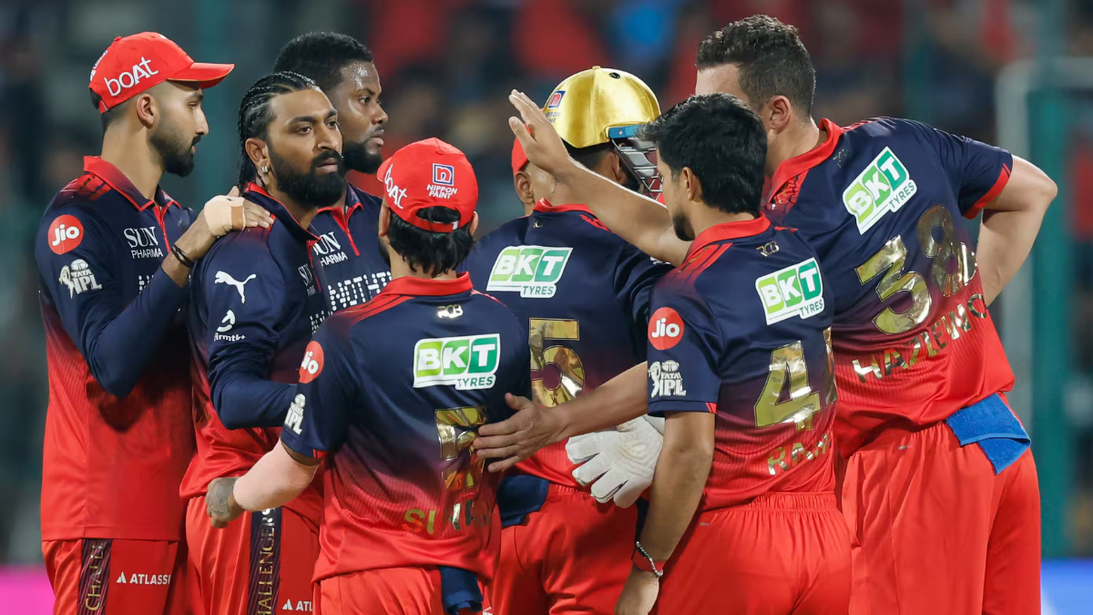 Royal Challengers Bengaluru (RCB) players, including Krunal Pandya and Josh Hazlewood, celebrating a wicket during their T...
