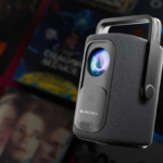 Zebronics ZEB-PixaPlay 77G Smart Projector with remote and a background of streaming shows.