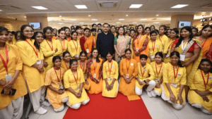 Gautam and Priti Adani with a large group of female trainees in yellow uniforms during the new Bihar eye hospital launch.