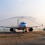 White Air India A320neo aircraft receiving a ceremonial water salute on the runway tarmac in Hanoi.