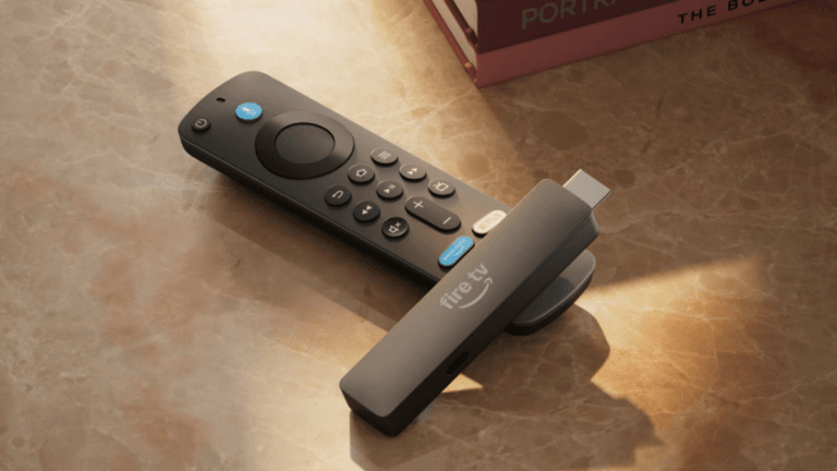 Amazon Fire TV Stick dongle resting on its voice remote on a sunlit marble table, representing the new India launch.