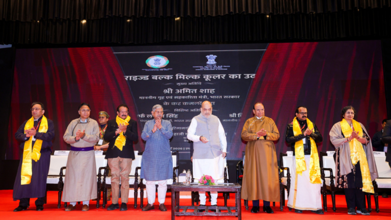 Officials on stage with a backdrop for dairy infrastructure inauguration in Leh Ladakh.